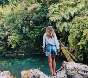 Mujer de espaldas viendo el bosque y río en el Parque Nacional Puyehue